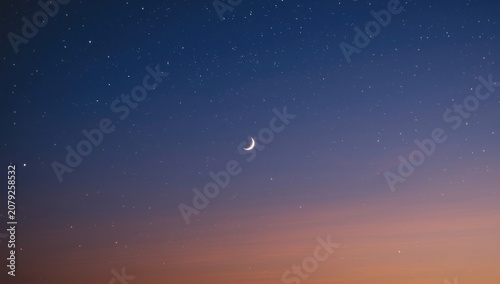 Peaceful twilight view highlighting radiant crescent moon and starry sky