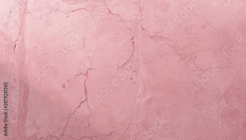 surface texture of pale pink concrete wall highlighted by visible cracks along length