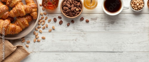 Croissants, coffee, and assorted nuts on a wooden table