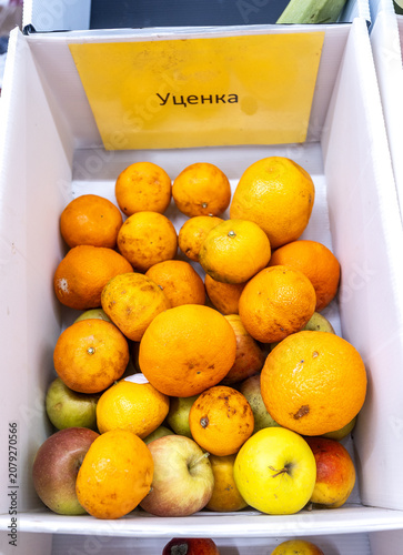 Сardboard box with spoiled rotten fruits. Text in russian: Markdown