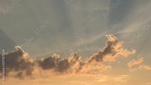 Schilderij op canvas Soft sunset clouds with gentle sunbeams in evening sky