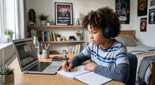 Boy in headphones math lesson laptop bedroom desk