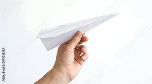 Hand holding white paper airplane.