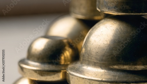 macro of old brass balance scale weights stacked soft side light metallic texture muted background