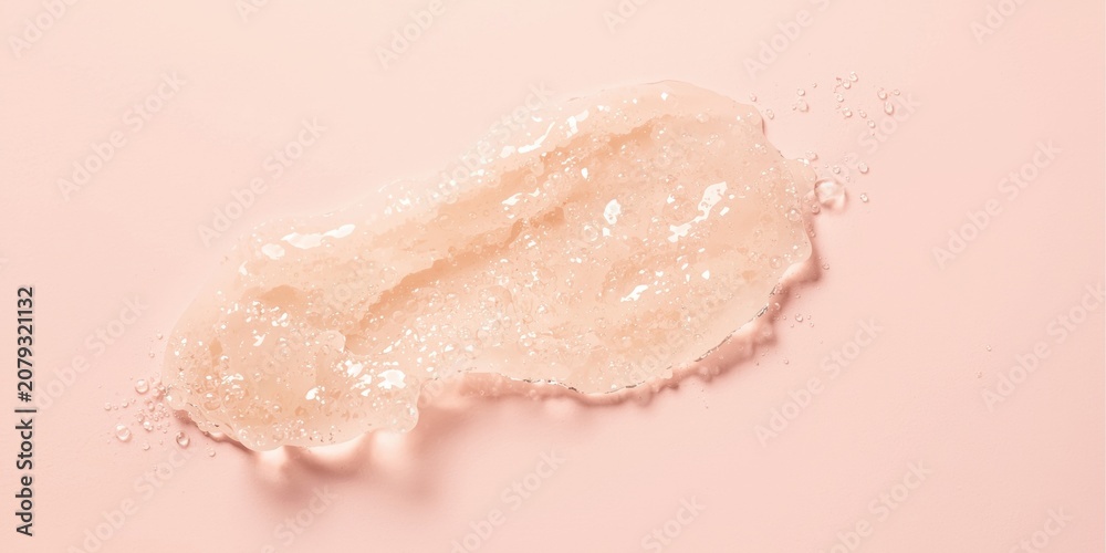 Fototapeta premium Clear gel texture with water droplets on pink background