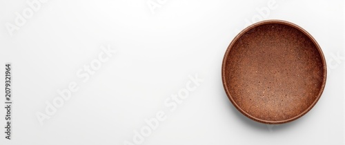 Brown ceramic bowl on a whi...
