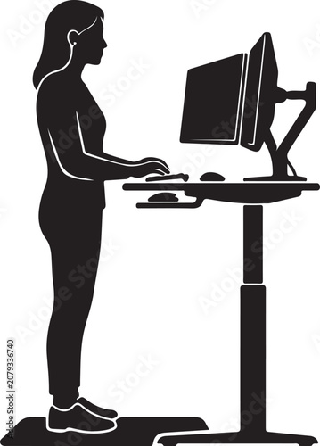 Woman standing at desk with computer monitor and keyboard  working on computer