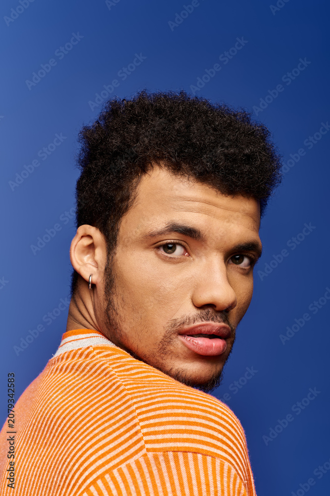 Fototapeta premium A charming african american man showcases his captivating expression while looking over his shoulder.
