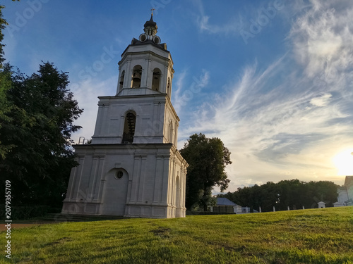 Photography White stone chapel with steeple bell cross, and arched doors in summer sun day u