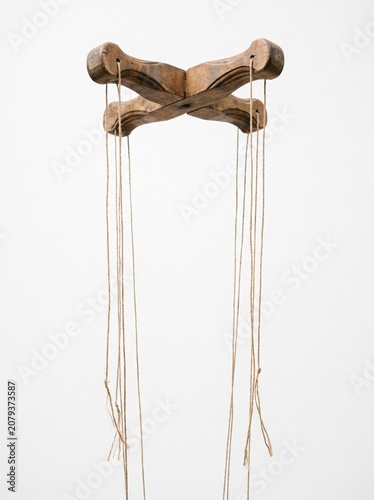 Wooden Marionette Control Bar with Hanging Strings as a Control and Manipulation Metaphor