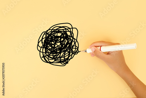 Hand drawing a tangled scribble on a pastel background. Concept of confusion, stress, overthinking, mental clutter, problem solving and chaotic thoughts.