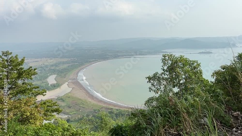 Beautiful seascape view of gentle ocean waves rolling on a sandy beach under a bright sky