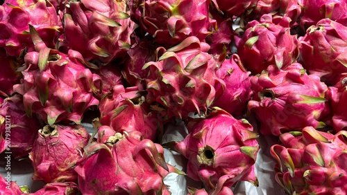 Full frame background of fresh ripe pink dragon fruits on display at a market stall