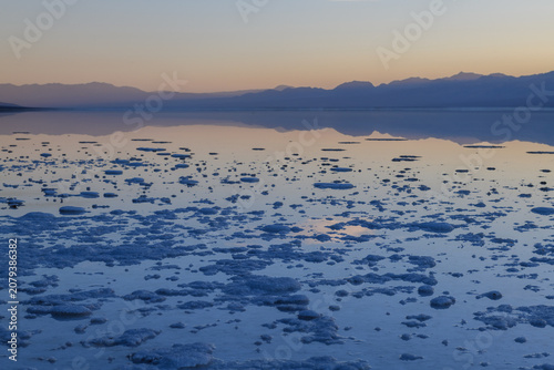 Sierra nevada california saline lake salt flat dawn mountain reflection calm shore in tranquil desert landscape with blue crust