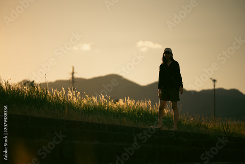Silhouette woman grass suns...
