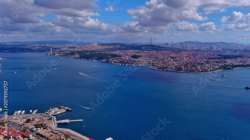 Aerial drone view of the Bosphorus strait separating Europe and Asia, with the Maiden's Tower, Camlica Tower, and Istanbul's Anatolian shore, Turkey, daytime.