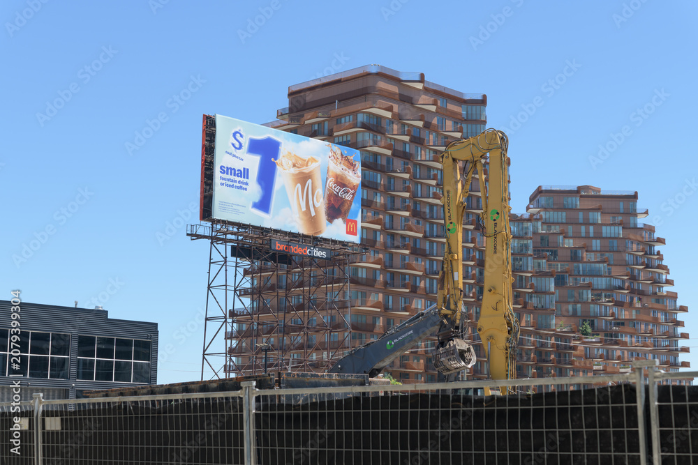 Obraz premium heavy construction machinery (Blackcore Environmental, a prominent Toronto-based demolition, excavation, and environmental services company) and view of spectacular with ad for McDonald's and condo