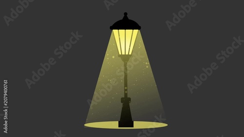 A classic vintage lamppost illuminates the darkness with a bright yellow light cone filled with floating dust particles.