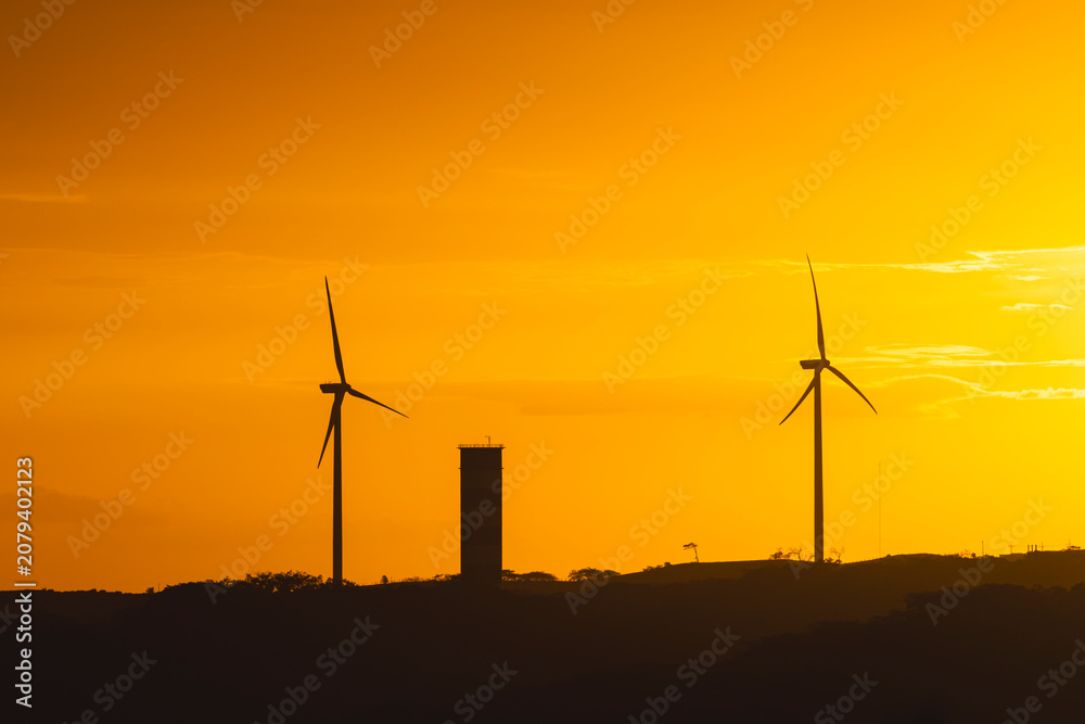 Obraz premium Wind turbines generating clean energy at sunset