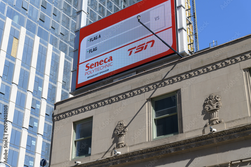 Obraz premium rooftop electronic billboard for Seneca Polytechnic and TSN atop the historic Dominion Bank Building by John M Lyle, 1930, Gerrard St W and Yonge St, Toronto
