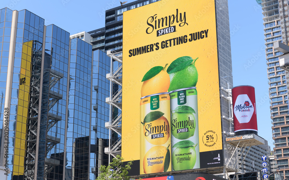 Obraz premium LED spectacular with advertising for Simply Spiked, an alcoholic beverage brand (spiked lemonade/fruit drinks), produced by Molson Coors, facing Sankofa Square, Toronto