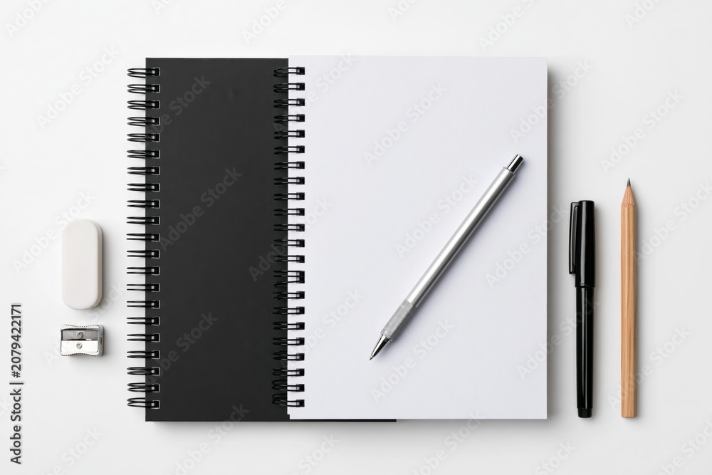 Naklejka premium Notebook with spiral binding and office stationery supplies on a white background