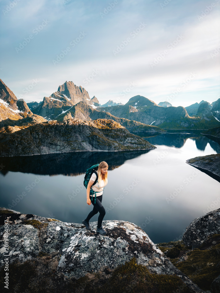 Obraz premium Woman hiking solo in Norway explore Lofoten islands travel active healthy lifestyle summer vacations adventure tour outdoor, tourist girl enjoying mountains and Solbjornvatnet lake view eco tourism