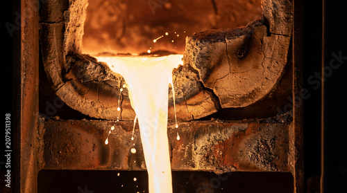 Molten steel flowing from a refractory furnace during industrial casting process