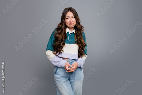 Canvas-taulu Young woman with an awkward, uneasy expression and hesitant body language in cas