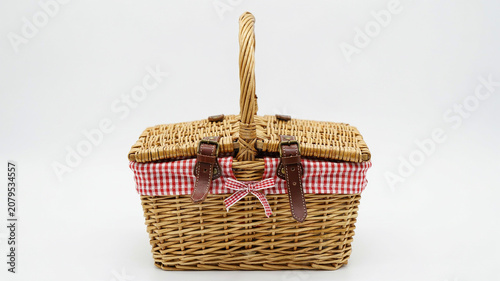 Wicker Picnic Basket With Red Gingham Liner and Leather Straps On White Background Keywords: picnic basket, wicker basket, woven basket, picnic, outing, food basket