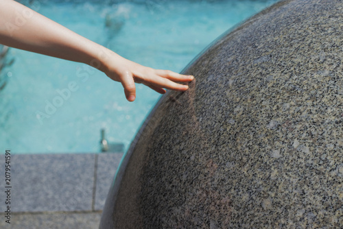 Cuadro en lienzo Child's Hand Touching Stone Fountain
