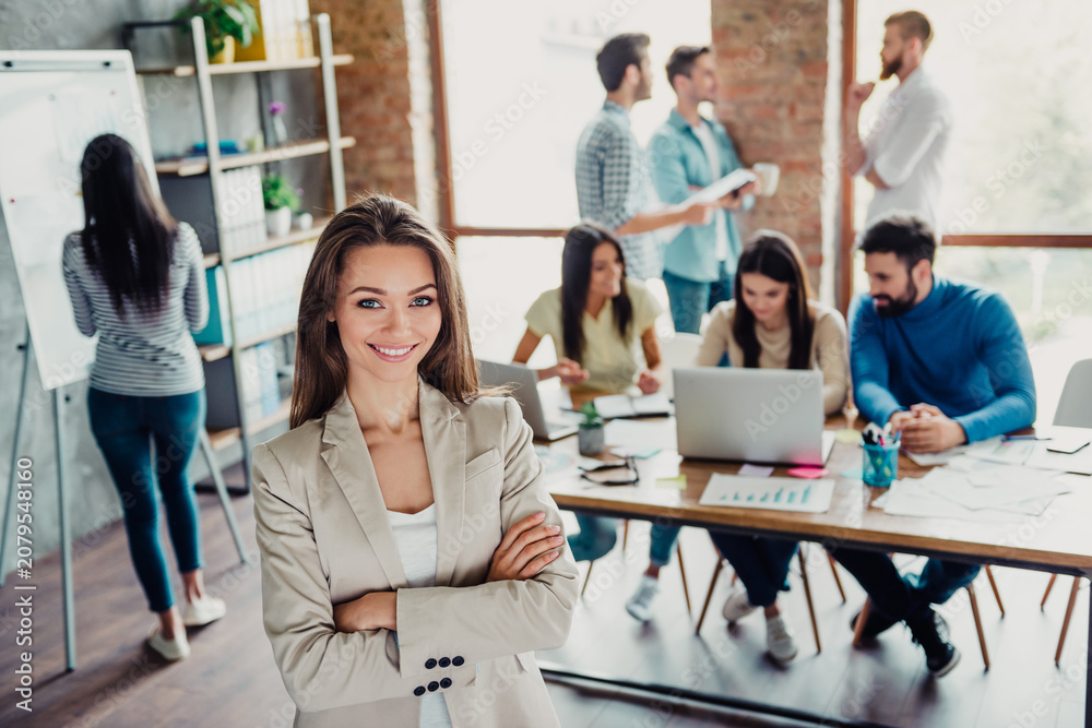 Fototapeta premium Confident businesswoman leading a creative office team in a modern startup workspace
