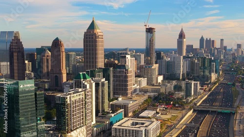 Urban Atlanta cityscape with modern skyscraper buildings and driving traffic on city highways. American transportation system and metropolitan mobility.