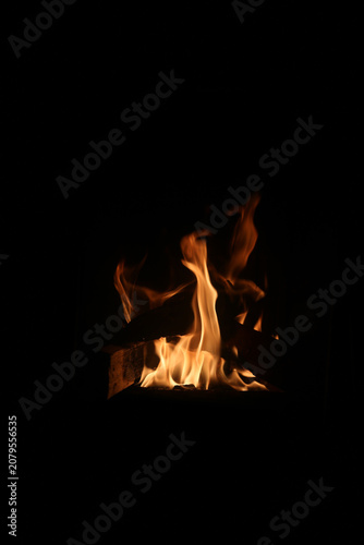 Burning wood with big red and orange flames. Fascinating abstract view symbolizing cooking, warmth, camping - and on the other hand burning, danger and hell. Closeup image.