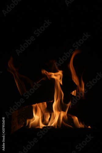 Burning wood with big red and orange flames. Fascinating abstract view symbolizing cooking, warmth, camping - and on the other hand burning, danger and hell. Closeup image.