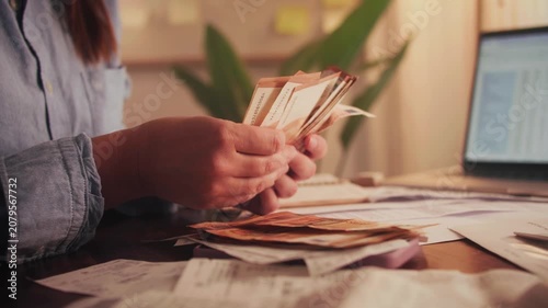 Close up of hands counting euros while sitting at a table. Utility bills and receipts are on the table. The process of calculating a family budget. High quality 4k footage