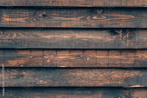 Obraz na płótnie Dark brown wooden fence panels creating a rustic, weathered wood texture backgro