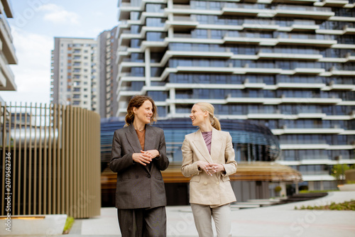 Women walk and talk in fron...