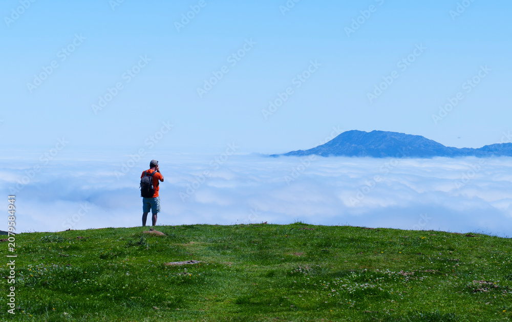 Obraz premium Man photographs sea of clouds in Picos de Europa