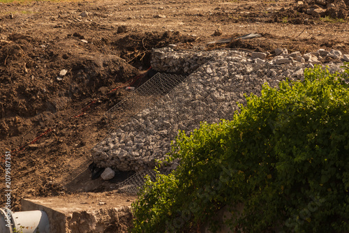 Quadro su tela Wire mesh retaining cages filled with stones for soil erosion control on a const