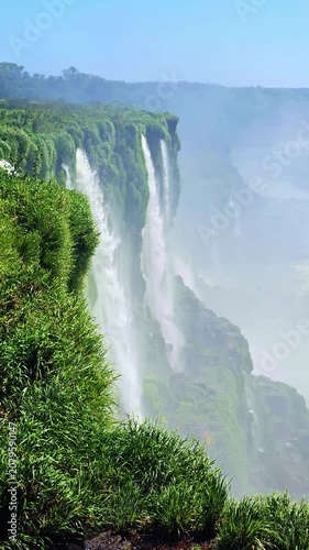 Magnificent view of iguazu falls in argentina, where powerful streams of water cascade down cliffs covered in lush, green vegetation