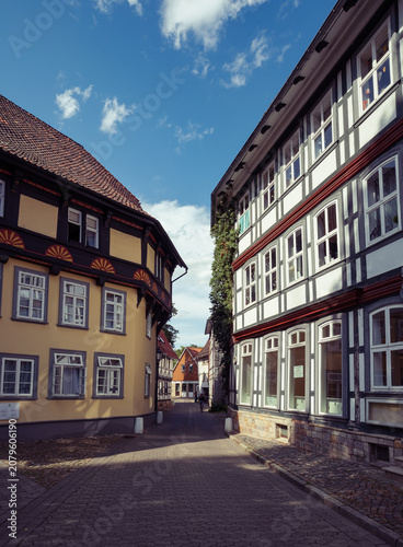 Photographer captures vertical perspective of picturesque medieval alley featuring flowers and overhanging floors