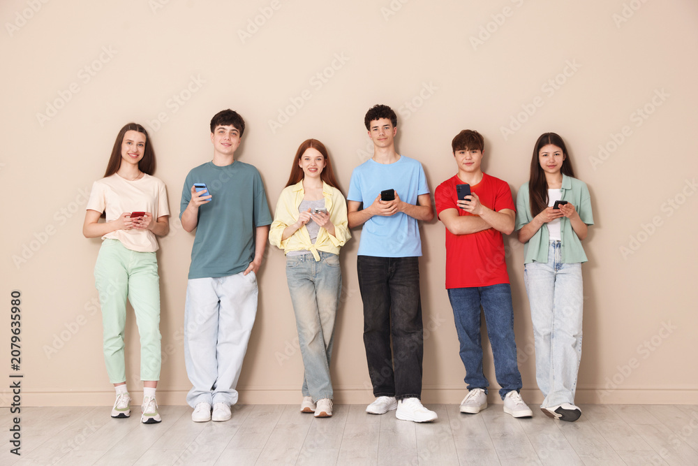 Obraz premium Group of teenagers with different smartphones indoors