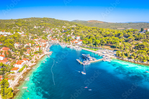 Drone photo of Maslinica showing the picturesque bay, village center, turquoise Adriatic Sea, marina, stone houses and beautiful Mediterranean coastline on Solta Island Croatia