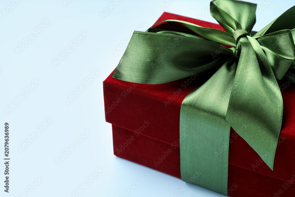 Fototapeta premium Beautiful velvet gift box on light blue background, closeup. Space for text