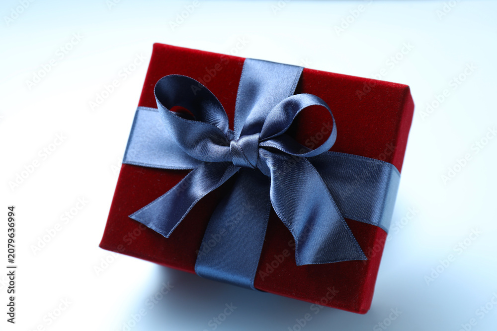 Fototapeta premium Beautiful velvet gift box in air on light blue background, closeup