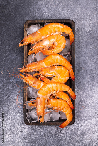Fresh cooked shrimp on ice in wooden tray