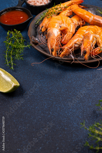 Cooked fresh prawns serving with sauce and herbs