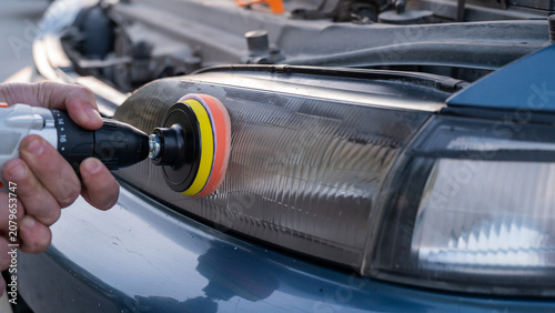Foto The process of polishing car headlights outdoors.