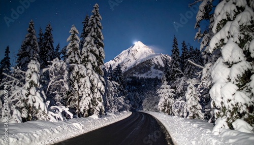 beautiful winter road with dark night road through forest and mountains, wintery scene at sunset